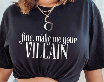 May include: A black t-shirt with the text "fine, make me your VILLAIN" in white lettering. The shirt is tied at the waist and worn with light blue denim shorts.