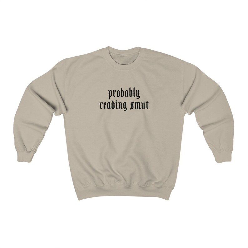 Puede incluir: Sudadera beige con mangas largas. El texto "probably reading smut" est&aacute; impreso en negro, con una fuente de estilo g&oacute;tico en el pecho. La sudadera est&aacute; hecha de un material suave.