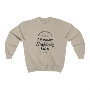 May include: A beige sweatshirt with a black graphic print that reads "The Secret Society of Obstinate Headstrong Girls Est. 1813".
