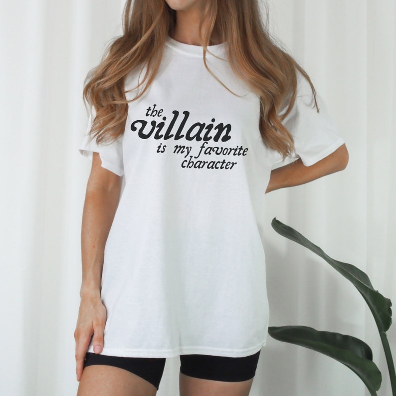May include: White t-shirt with black text that reads "the villain is my favorite character"