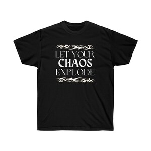 May include: Black t-shirt featuring the white text "LET YOUR CHAOS EXPLODE" in a decorative font, with flame-like designs. The shirt has a crew neck.