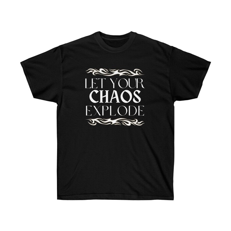 May include: Black t-shirt featuring the white text "LET YOUR CHAOS EXPLODE" in a decorative font, with flame-like designs. The shirt has a crew neck.