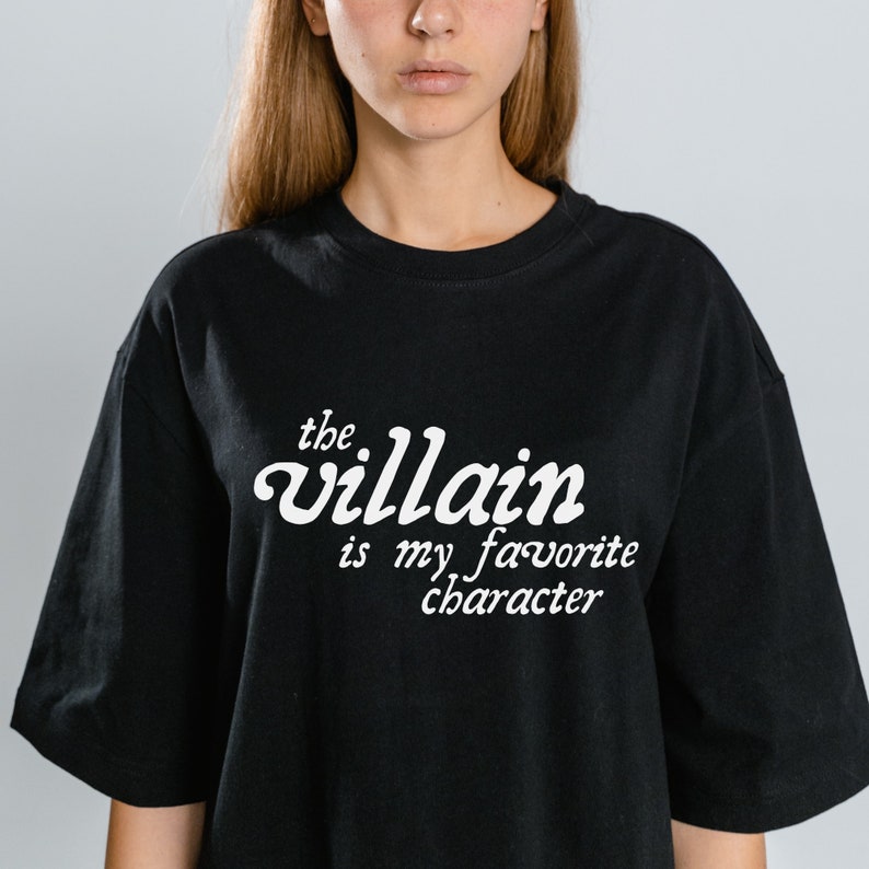 May include: Black t-shirt with white text that reads "the villain is my favorite character"