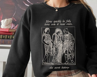 Puede incluir: Sudadera negra con un estampado gráfico blanco de tres figuras y el texto "How quickly he fell, how soon it was over. -the secret history-"