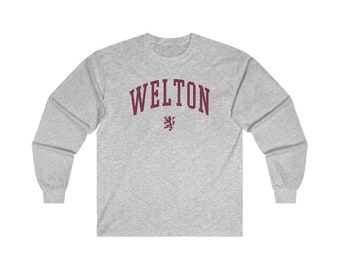 May include: A gray long-sleeve t-shirt with the word "WELTON" printed in maroon on the front. A maroon lion crest is below the text.