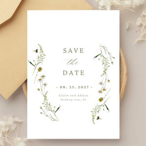 Könnte beinhalten: Eine weiße Save the Date-Karte mit floralen Illustrationen und Bienen. Der Text lautet "Save the Date" mit dem Datum "08. 25. 2027" und den Namen "Claire und Aditya" mit dem Ort "Wedding town, NY".