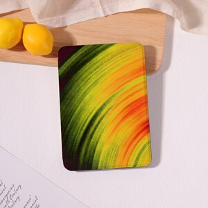 May include: A rectangular tablet case featuring a vibrant abstract design of concentric circular brushstrokes in shades of deep forest green, bright lime, sunny yellow, and warm orange, creating a dynamic sense of motion across the surface.