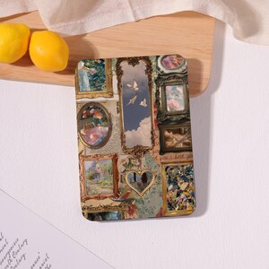 May include: A rectangular phone case featuring a collage of framed paintings in various styles. The artwork includes landscapes, portraits, and floral arrangements, with a heart-shaped mirror and a sky with birds.