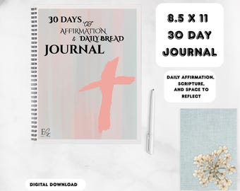 May include: A spiral-bound journal with the text "30 Days of Affirmation & Daily Bread Journal" and a pink cross graphic. The journal is 21.6 x 27.9 cm and includes space for daily affirmations, scripture, and reflection. A white pen is next to the journal.