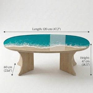 May include: An oval coffee table with a light wood base and a resin top featuring a teal ocean design with white foam waves. The table measures 47.2 inches in length, 23.6 inches in width, and 18.5 inches in height as indicated by the text labels.