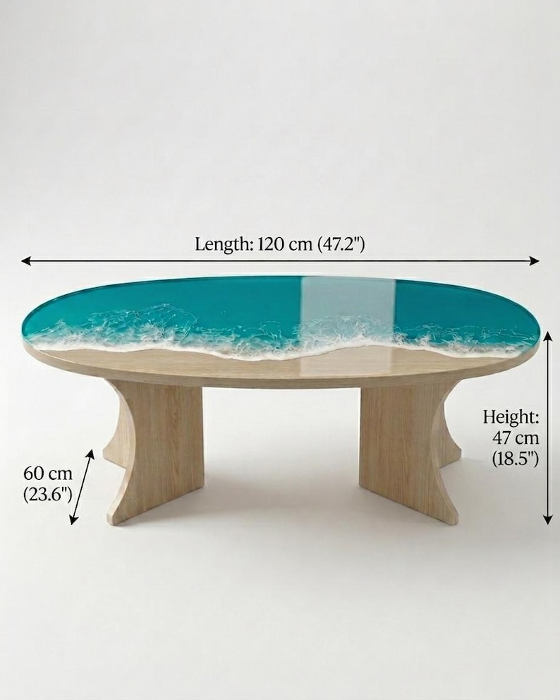 May include: An oval coffee table with a light wood base and a resin top featuring a teal ocean design with white foam waves. The table measures 47.2 inches in length, 23.6 inches in width, and 18.5 inches in height as indicated by the text labels.