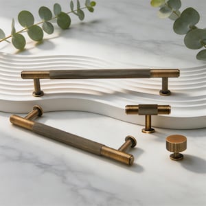 May include: A collection of antique brass cabinet hardware including two long bar pulls, one T-shaped pull, and one round knob. Each piece features a textured, ribbed center section with smooth ends and cylindrical mounting posts for attachment.