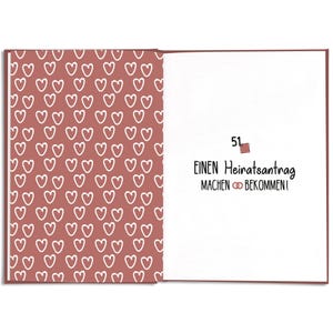 May include: Open book with a red cover. The left page has a pattern of white hearts on a red background. The right page has the number 51, and German text that translates to "Make a proposal, get married!"