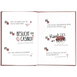 May include: Open book with German text and illustrations. Page 84 says "Visit a Casino!" with a casino chip illustration. Page 87 says "Kiss in the Rain!" with rain drops. Other pages have text and illustrations.
