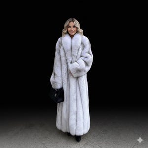 Puede incluir: Un abrigo largo de piel de color gris claro con un cuello ancho y mangas largas. El abrigo se lleva con zapatos negros y un bolso de mano negro. El fondo es negro liso.