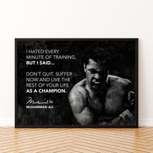 May include: Black and white framed print featuring a portrait of Muhammad Ali. The print includes a quote attributed to Ali: "I hated every minute of training, but I said... Don't quit. Suffer now and live the rest of your life as a champion."