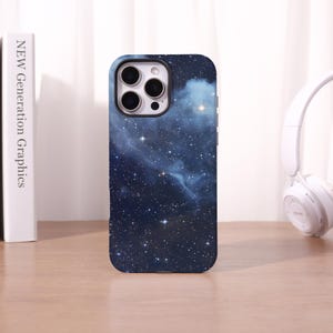 May include: A smartphone case featuring a deep blue and black outer space design with a dense field of white stars and soft, glowing nebulae. The case has a rectangular cutout at the top left for a triple-lens camera system and flash.