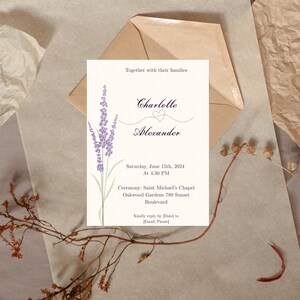 May include: Ivory wedding invitation featuring a lavender floral design. The invitation includes the names "Charlotte" and "Alexander", the date, time, and ceremony location. An envelope is behind the invitation.