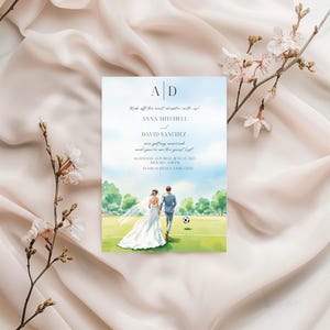 Könnte beinhalten: Hochzeitseinladung mit einer Aquarellillustration eines Paares, das auf einem Fußballfeld geht. Die Einladung enthält die Namen Anna Mitchell und David Sanchez mit Veranstaltungsdetails. Der Hintergrund ist ein sanfter blauer Himmel und ein grünes Feld.