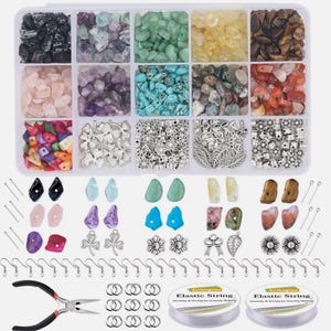 Könnte beinhalten: Ein Schmuck-Bastelset mit einer Vielzahl von bunten Edelsteinen, Perlen, Charms, Ohrhaken und elastischem Faden. Das Set enthält einen Kunststoff-Organizer mit mehreren Fächern, die mit verschiedenen Arten von Steinen und Perlen gefüllt sind.