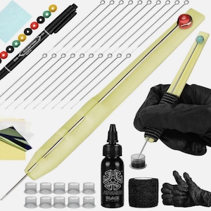 May include: A selection of tattoo equipment, including a black marker, needles, ink, and a tattoo pen. The image also shows ink caps, a roll of black grip tape, and a pair of black gloves.