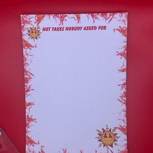 May include: A white notepad with a red and orange flame design border and the text "HOT TAKES NOBODY ASKED FOR" at the top. The notepad features a cartoon sun graphic in the corners. The notepad is on a red background.