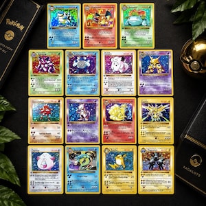 May include: A collection of twelve holographic Pokémon trading cards arranged in a grid, featuring characters like Blastoise, Charizard, Venusaur, Nidoking, Poliwrath, Clefairy, Alakazam, Hitmonchan, Mewtwo, Ninetales, Zapdos, Chansey, Gyarados, Raichu, and Magneton.