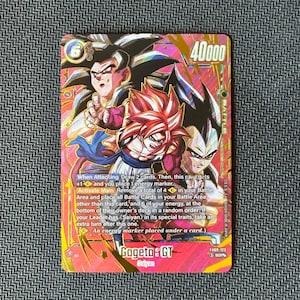 May include: A collectible trading card featuring the character Gogeta: GT with a power level of 40000. The card displays vibrant pink and gold artwork of three anime figures, with detailed game text, energy symbols, and the card code FB09-123.