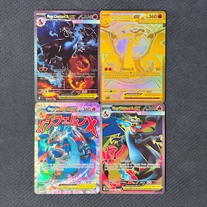 May include: Four Mega Charizard X EX trading cards featuring 360 HP, Inferno X attacks, and various artistic illustrations including a gold foil version and one with Japanese text, all displayed in a two-by-two grid arrangement.