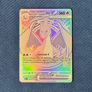May include: A holographic Mega Charizard Y EX trading card with a rainbow foil finish. The card displays the character illustration, 360 HP, the Explosion Y attack text, and the number 294/217. It features fire energy symbols and stage 2 status.