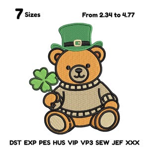 Op de afbeelding: Geborduurd ontwerp van een teddybeer met een groene leprechaun hoed en een groene klaver met vier bladeren. De beer draagt een beige trui. De afbeelding bevat de tekst "7 Maten" en "Van 2,34 tot 4,77".