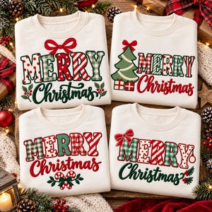 May include: Four off-white crewneck sweatshirts featuring festive holiday graphics. Each shirt displays the text Merry Christmas in various red and green patterns including polka dots, stripes, and plaid, accented with bows, trees, and holly.
