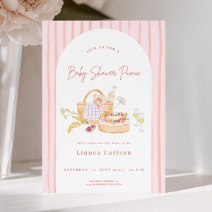 Op de afbeelding: Een babyborrel picknick uitnodiging met een aquarel ontwerp. De uitnodiging heeft een roze gestreepte achtergrond en een boogvorm met de tekst "Baby Shower Picnic". De uitnodiging bevat de naam "Linnea Carlson" en evenementdetails.