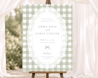 May include: A rectangular wedding welcome sign featuring a sage green and white gingham pattern. The center displays a white oval frame with a lace-like border, containing the text: Welcome to the wedding of Emma Rose and James Carter, May 22, 2027.