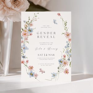 Floral gender reveal invitation featuring watercolor wildflowers in soft pink and blue tones arranged in a vertical frame with delicate butterflies. Elegant garden-inspired gender reveal invite with pastel colors and refined typography. Editable Canva gender reveal invitation perfect for wildflower gender reveals, neutral baby celebrations and spring garden events.