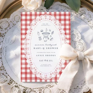 May include: A baby shower invitation with a red and white gingham pattern background. The invitation features a white oval frame with a BBQ illustration and text that reads "summer backyard BABY-Q SHOWER" and event details. A white ribbon and lace trim the invitation.