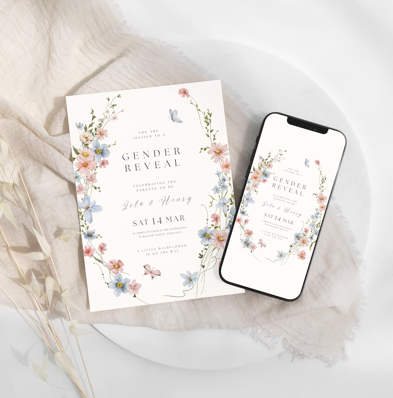 May include: A gender reveal invitation card and a smartphone displaying the same design. The white card features a watercolor floral wreath with pink and blue flowers, butterflies, and text reading Gender Reveal, Lila & Henry, Sat 14 Mar.