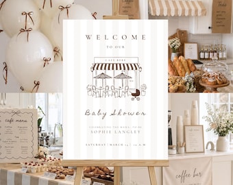 May include: A baby shower scene with a sign that reads "Welcome to our Cafe Bebe Baby Shower". The sign is on an easel, surrounded by balloons, pastries, and a coffee bar. The event is celebrating Sophie Langley.