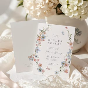 May include: A white gender reveal invitation card featuring a floral wreath of pink and blue wildflowers, green stems, and small butterflies. The text reads: You are invited to a Gender Reveal, celebrating the parents to be, Jile & Henry, Sat 14 Mar.