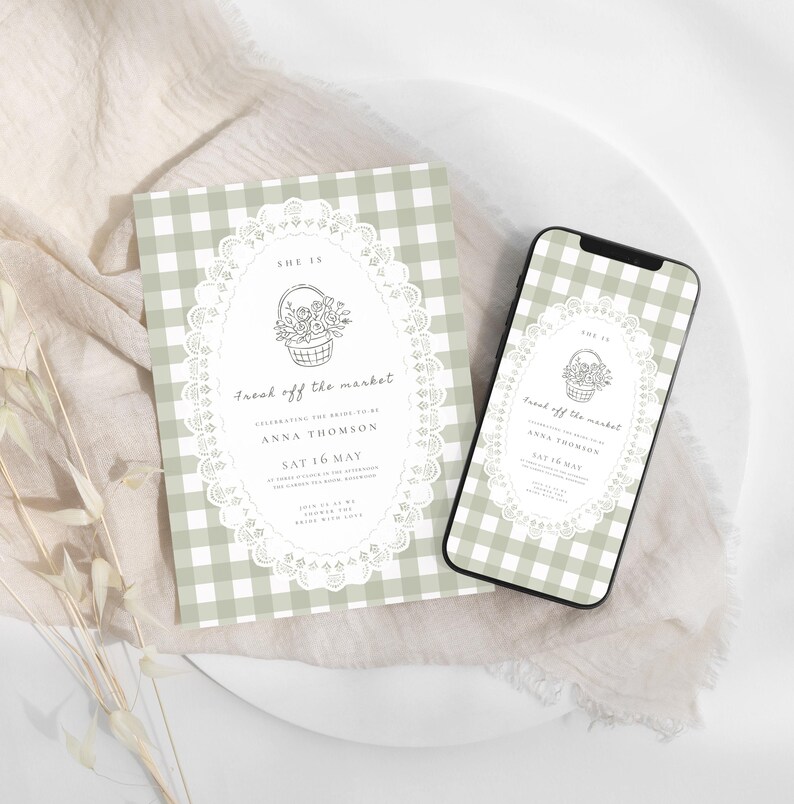 May include: A bridal shower invitation and a smartphone displaying the same design. The invitation and phone screen feature a gingham pattern in light green and white, with a floral basket illustration and the text "Fresh off the market."