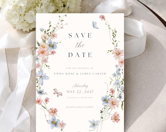 May include: A rectangular Save the Date wedding card featuring a watercolor floral wreath in shades of pink and blue with small butterflies. The text reads Save the Date for the wedding of Emma Rose and James Carter, Saturday May 22, 2027, Nashville, Tennessee, formal invitation to follow.