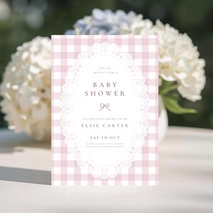 May include: A rectangular baby shower invitation card featuring a light pink and white gingham pattern. The center displays a white oval frame with a delicate lace border, containing text that reads: PLEASE JOIN US FOR A BABY SHOWER, ELSIE CARTER.