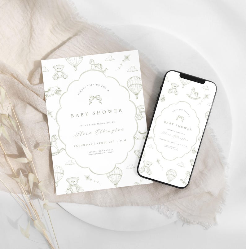 May include: A baby shower invitation and a smartphone showing the same design. The invitation and phone screen have a white background with a decorative border and illustrations of teddy bears, rocking horses, and hot air balloons. The text reads "Baby Shower".