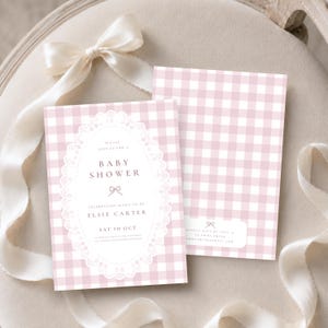 May include: A rectangular baby shower invitation card featuring a light pink and white gingham pattern. The center displays a white oval frame with a delicate lace border, containing the text: Please join us for a baby shower, Elsie Carter, Sat 10 Oct.