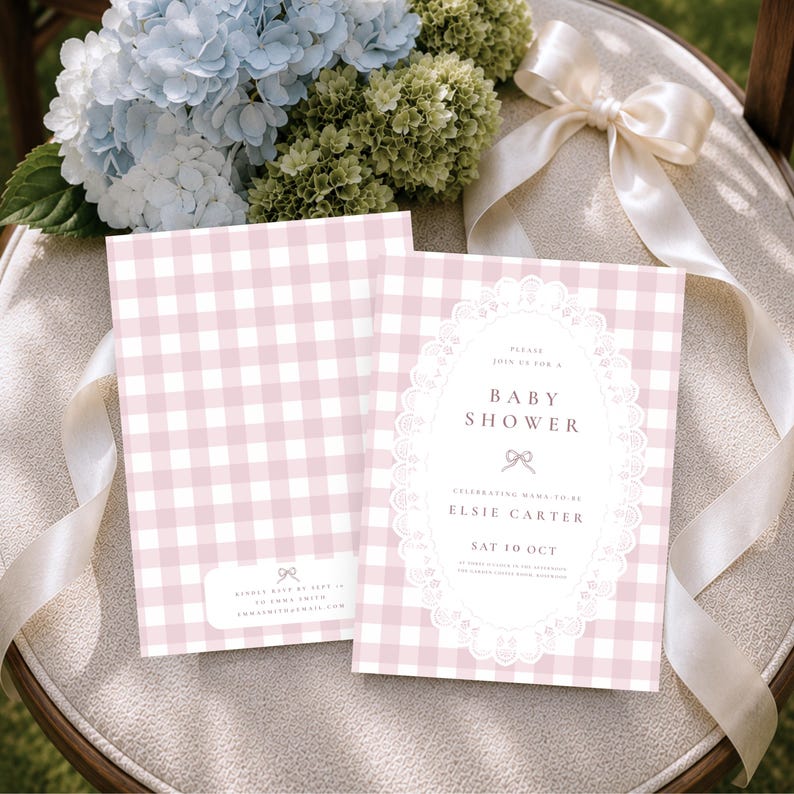 May include: Two rectangular baby shower invitation cards featuring a light pink and white gingham pattern. The front card displays a white oval frame with lace detailing, text reading "Please join us for a baby shower," "Elsie Carter," and "Sat 10 Oct."