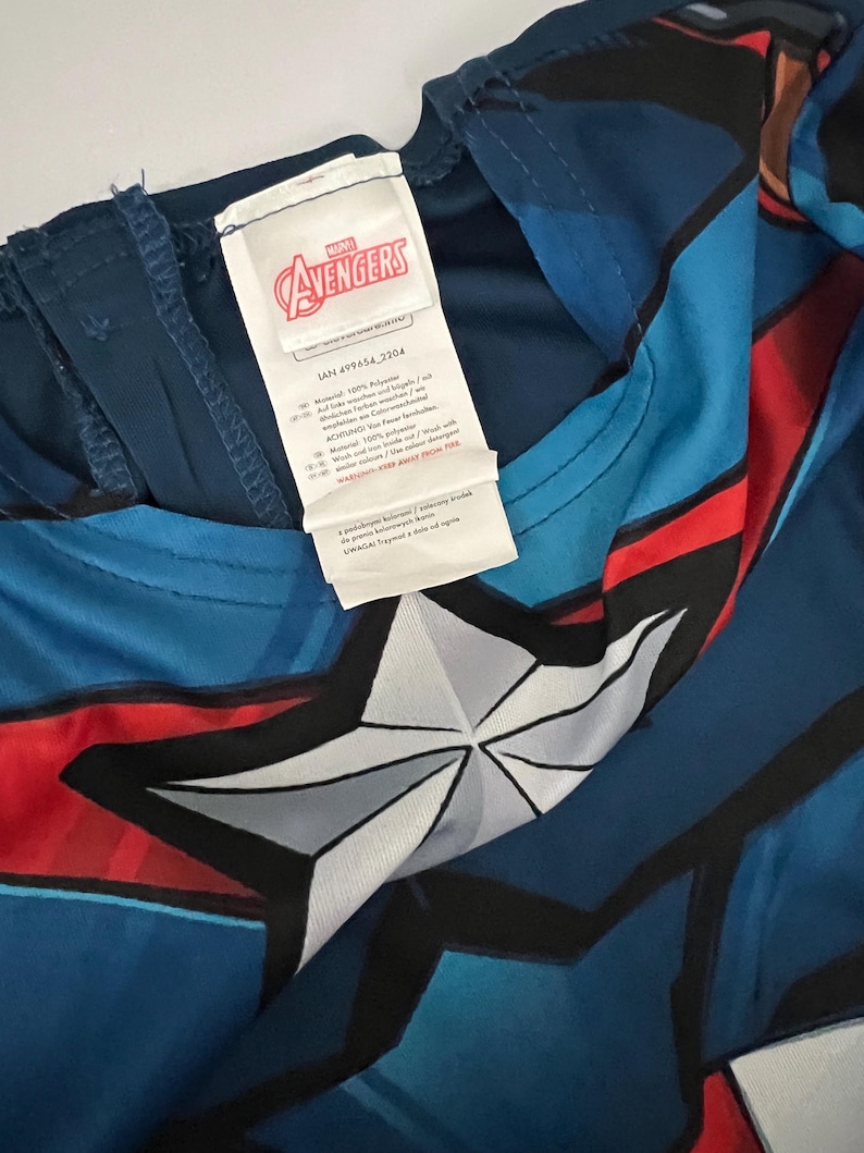 May include: Blue and red Avengers costume with a white star design. The costume has a tag with the Avengers logo and text. The costume is made of a lightweight material.