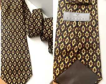 May include: A brown tie with a repeating floral pattern in gold and dark brown. The tie is made of a smooth fabric and features the brand name "Umberto Scolari" on a tag.