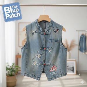 May include: Light blue denim vest with embroidered floral and dragonfly designs. The vest features a mandarin collar, red button closures, and a small pocket. The Blue Patch logo is visible in the upper left corner.