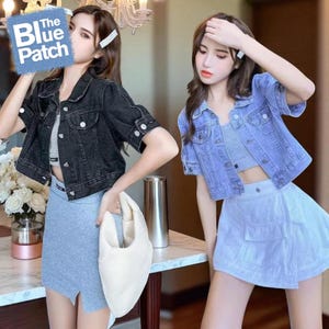 May include: Two women modelling denim jackets and skirts. One jacket is black, the other is light blue. The skirts are grey and light blue. One woman holds a white bag. The image has the text "The Blue Patch" in the upper left corner.
