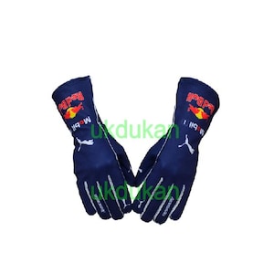 May include: Navy blue racing gloves with white detailing. The gloves display the Red Bull logo in red and yellow, and the Mobil 1 logo. The text "Aston Martin" is visible on the wrist area.